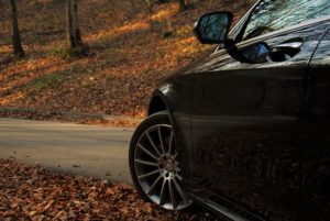 Avant de voiture Mercedes sur une route de forêt en automne.